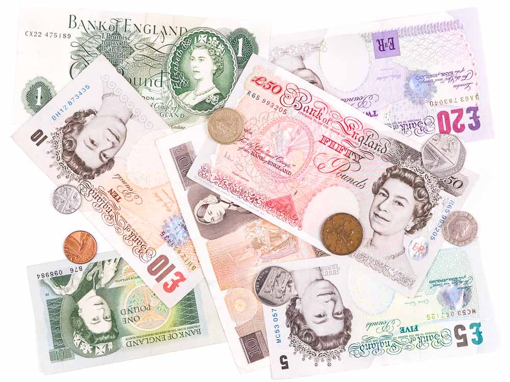 British Pound banknotes and coins scattered