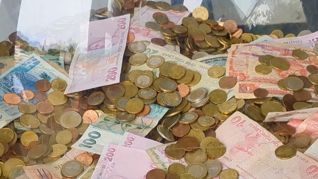 foreign banknotes and coins in a donation globe