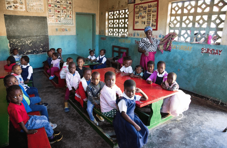school children seated at desks in a classroom.