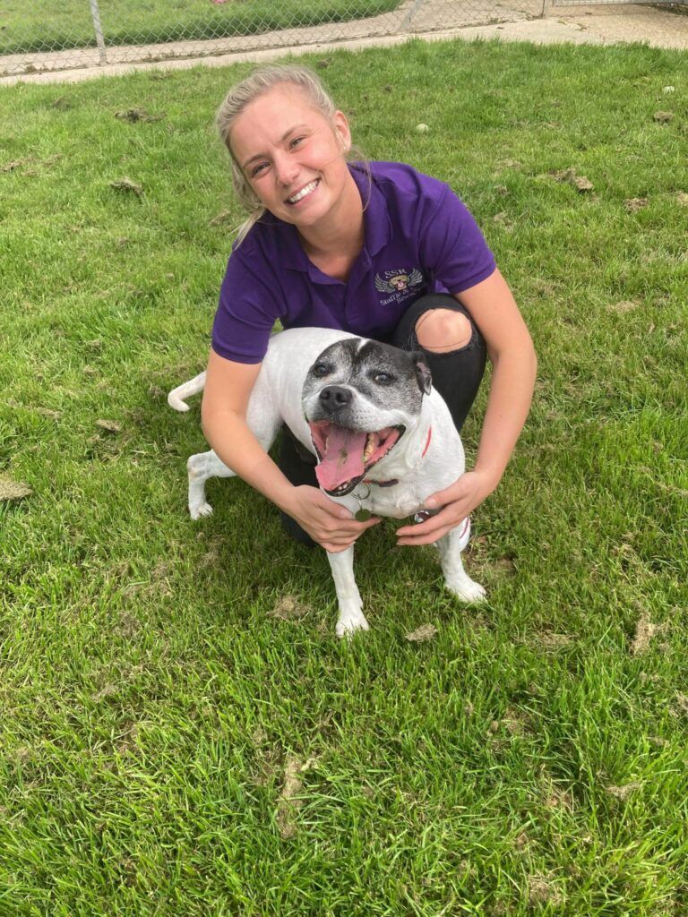 Volunteer at Staffie and Stray rescue hugging a rescue dog