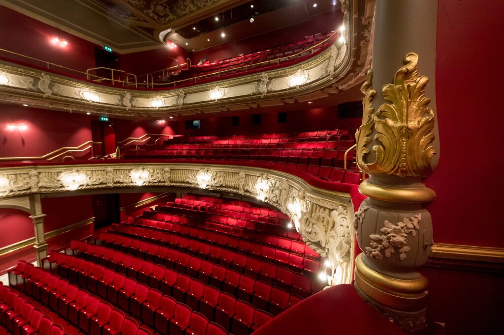 Inside the refurbished Lyric Hammersmith theatre showing seats and the balcony.