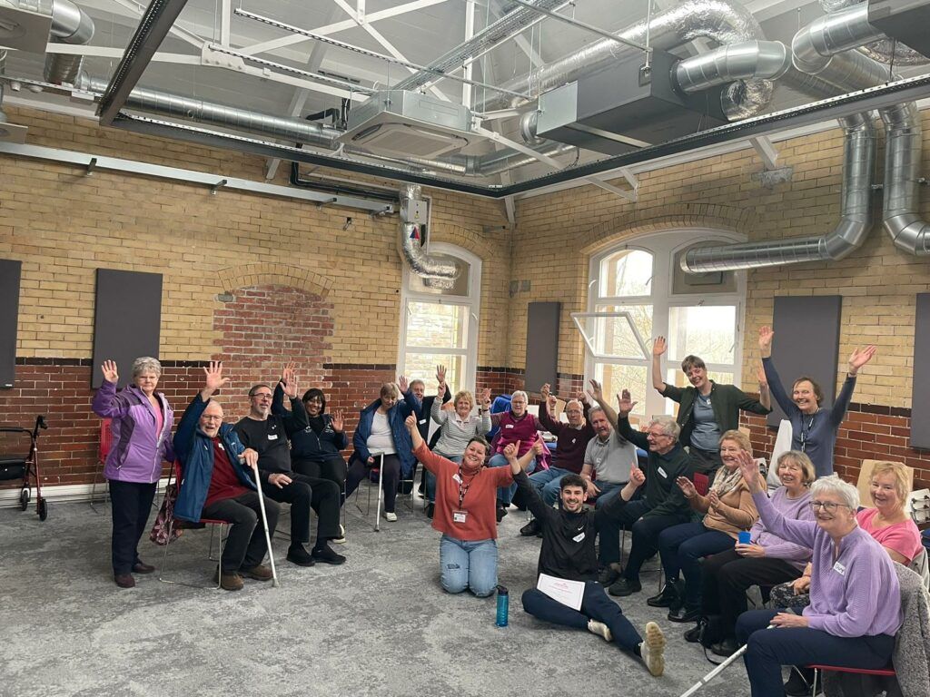 Bristol After Stroke charity with volunteers and people putting their hands in the air