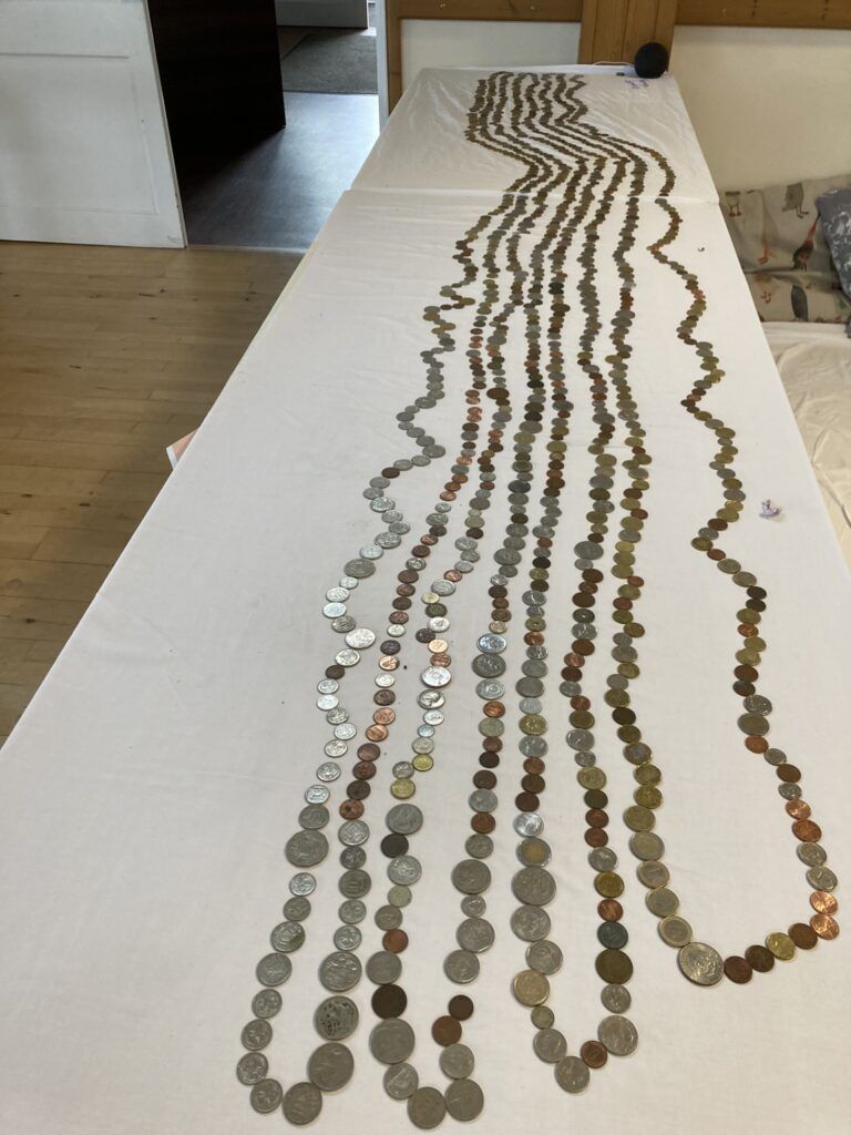 old and obsolete coins laid out in rows on a table