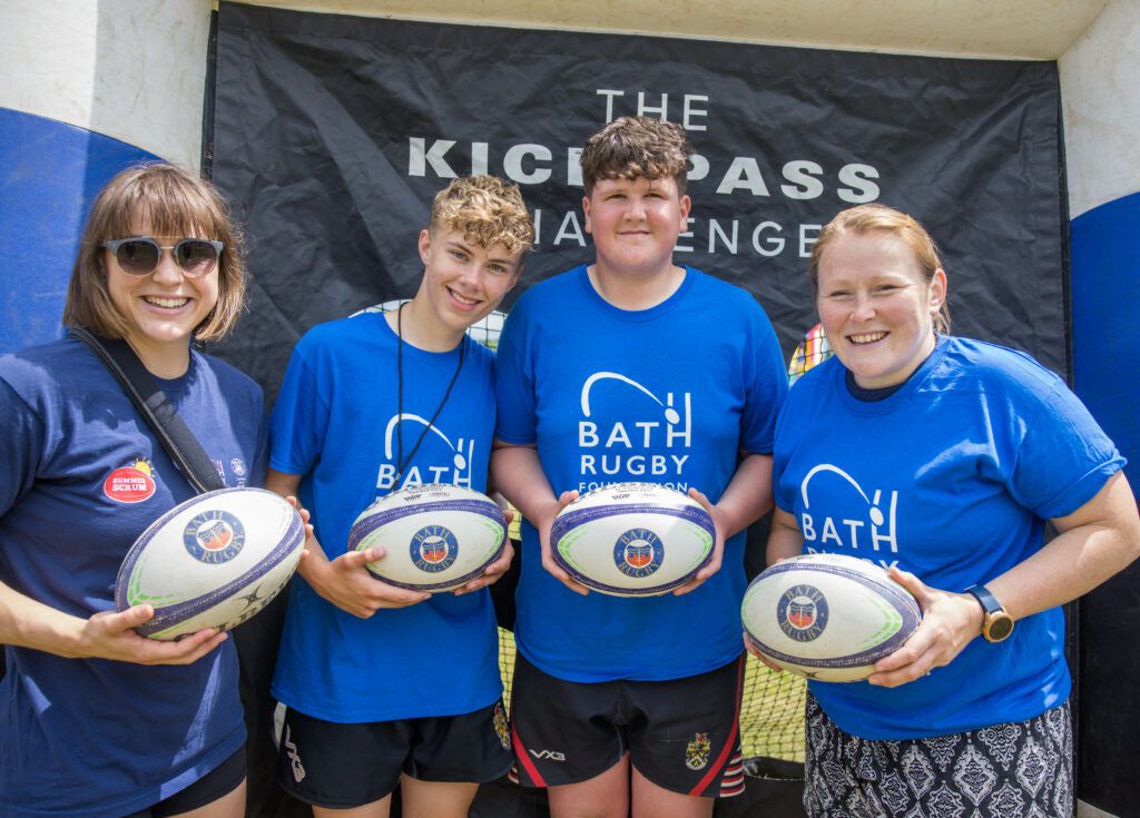 Bath Rugby Foundation volunteers holding a a rugby ball