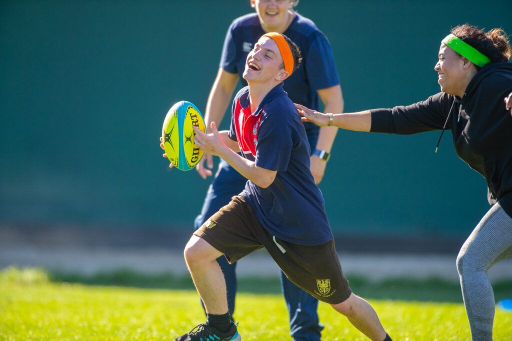 Bath Rugby Foundation volunteers and young teens playing rugby