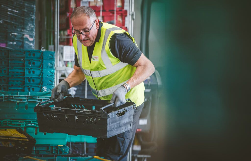 Member of FareShare Midlands moving crates of food