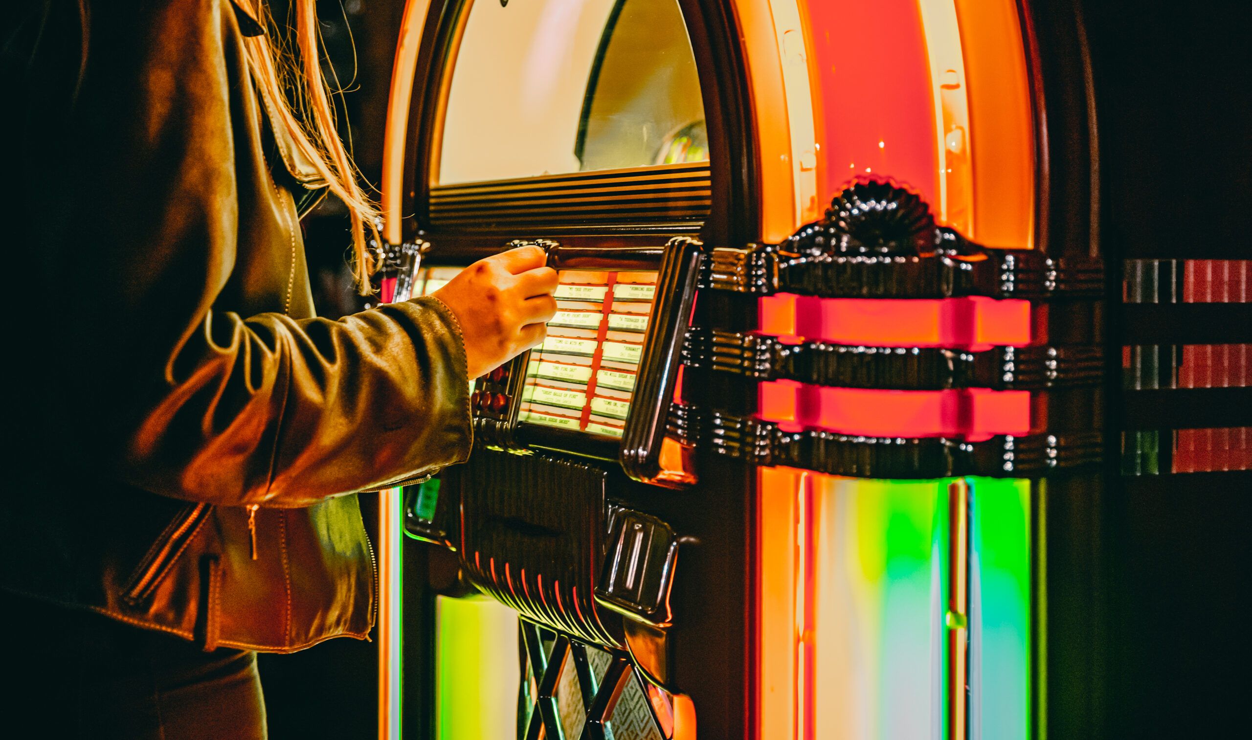 a person putting a coin in a jukebox